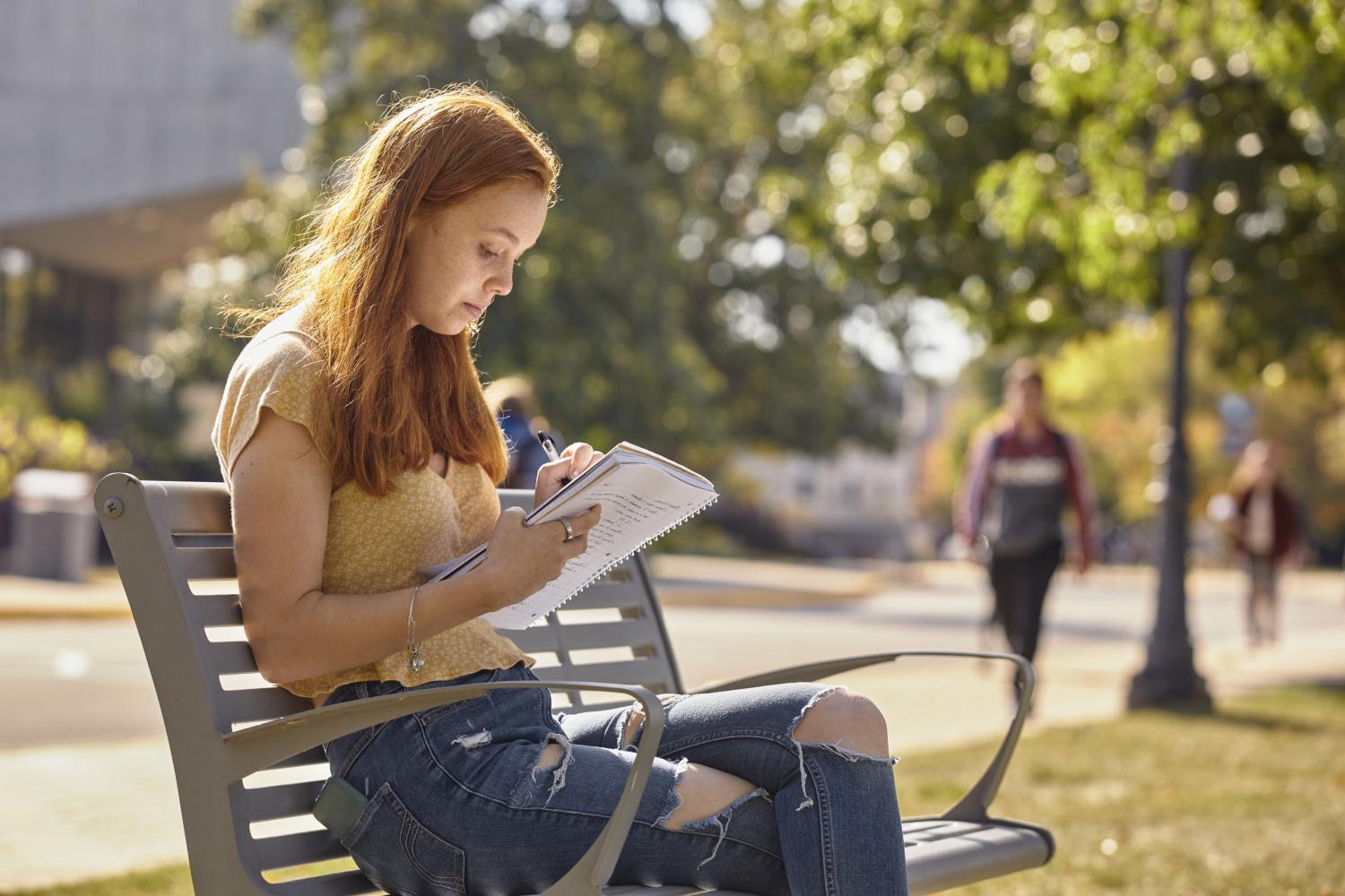 一位<a href='http://no.svfxtrade.net'>博彩网址大全</a>学院的学生在校园里的长椅上读书.